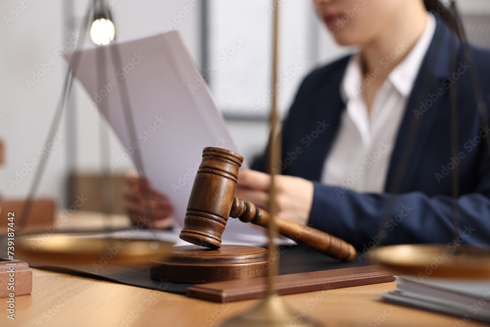 Notary reading document at table in office, focus on gavel Notary reading document at table in office, focus on gavel