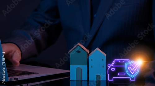 Businessman working with computer laptop and showing house model and animation of car with shield guard. Protection home and car insurance concept.