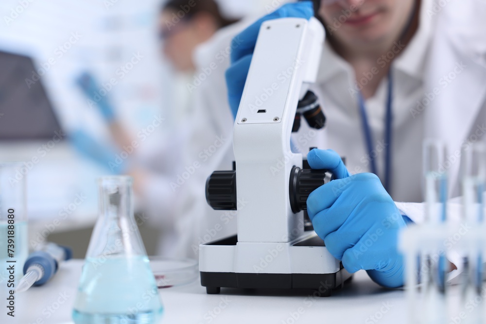 Scientist working with microscope in laboratory, closeup Scientist working with microscope in laboratory, closeup