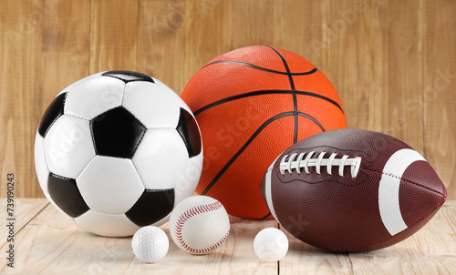 Many different sports balls on wooden background