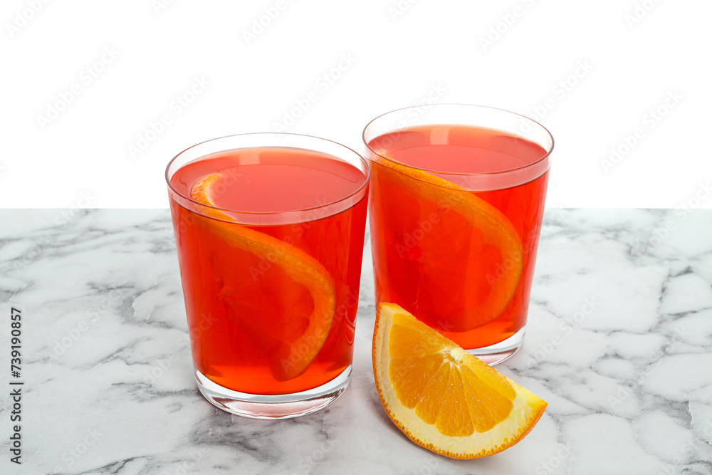 Aperol spritz cocktail and orange slices in glasses on marble table against white background Aperol spritz cocktail and orange slices in glasses on marble table against white background