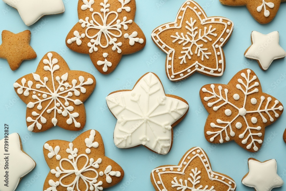 Tasty star shaped Christmas cookies with icing on light blue background, flat lay Tasty star shaped Christmas cookies with icing on light blue background, flat lay