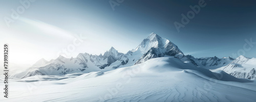 Snow-Capped Mountain Peak. Majestic snow covered winter mountain peak under a clear blue sky background with copy space. © IndigoElf