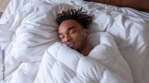 Happy african american man in white clothes blissfully sleeping on white bed with white blanket