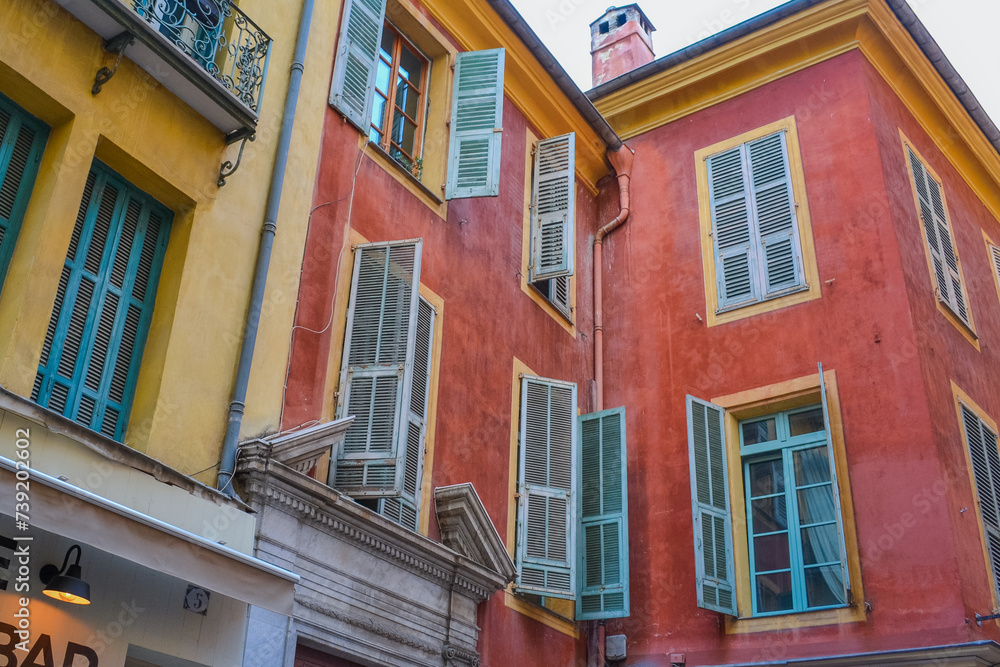 Fototapeta premium Nice, France, 02/13/2024: The architecture of the old town in Nice boasts a blend of Italian style with French motifs, characterized by colorful houses and narrow streets.