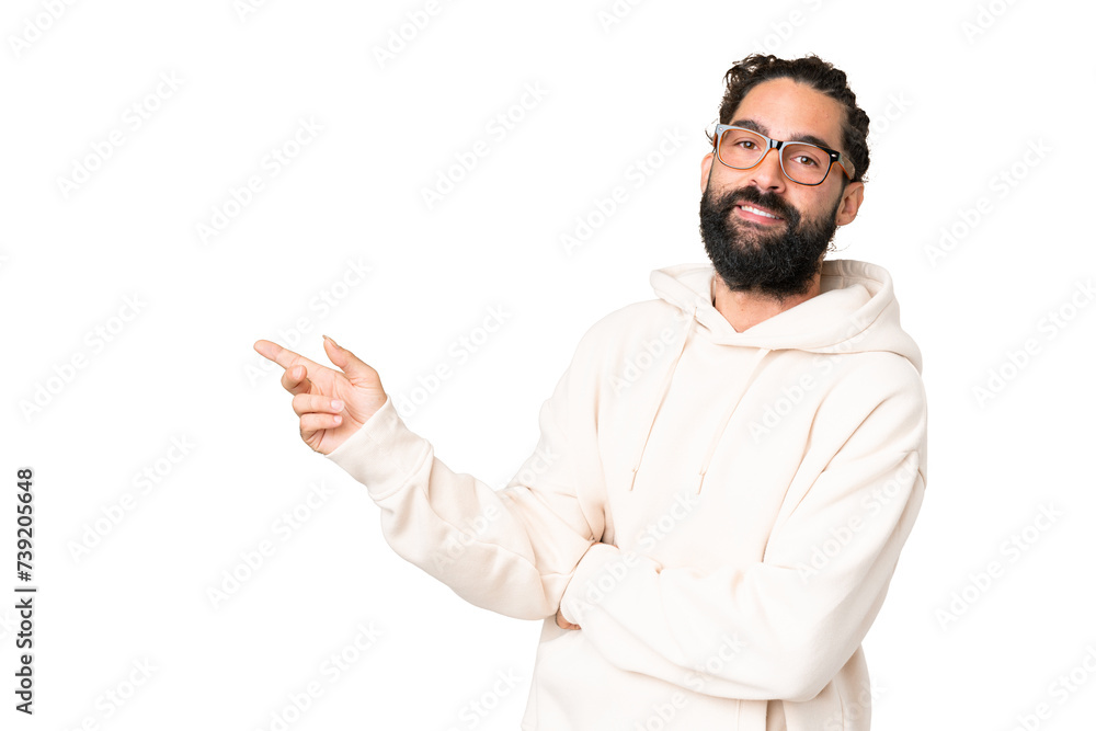 Young man with beard over isolated chroma key background pointing finger to the side
