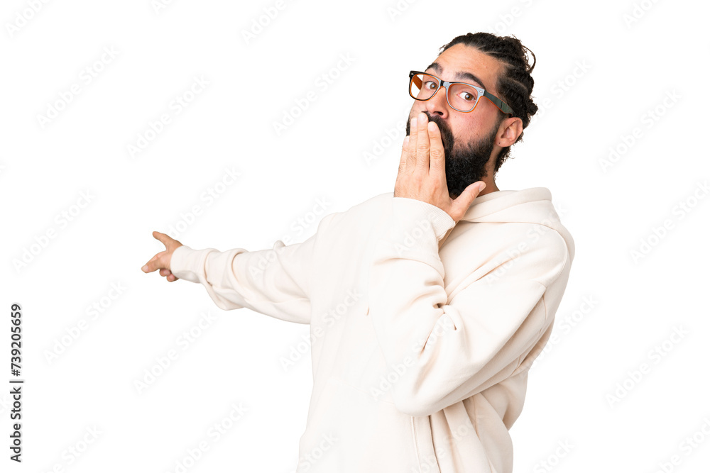 Young man with beard over isolated chroma key background with surprise expression while pointing side Young man with beard over isolated chroma key background with surprise expression while pointing side