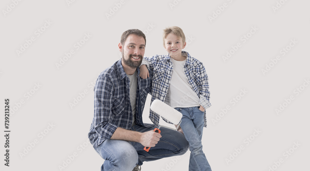 Father and young boy painting their home together