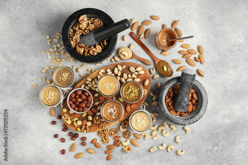Making nut butters from different nuts. Flat lay composition on light grey table