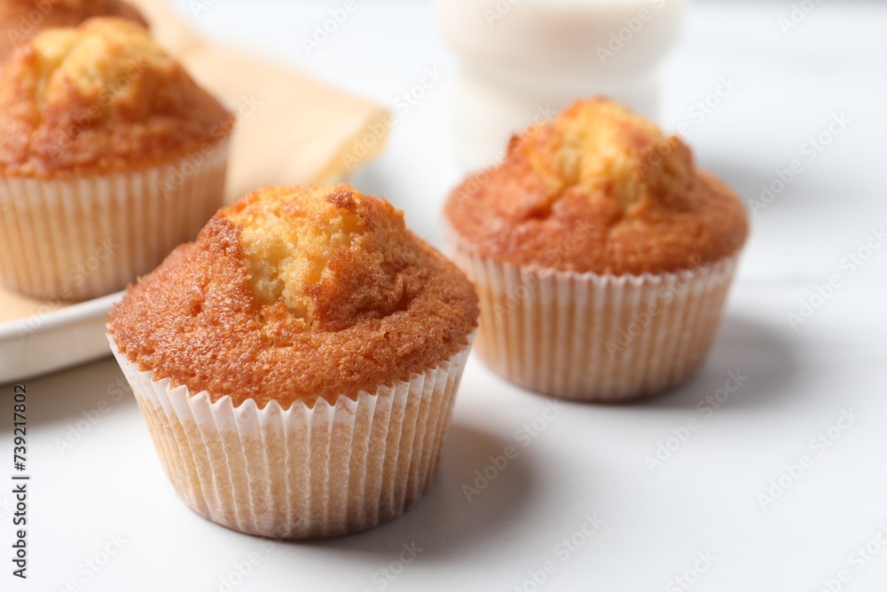 Delicious sweet muffins on white table, closeup. Space for text Delicious sweet muffins on white table, closeup. Space for text