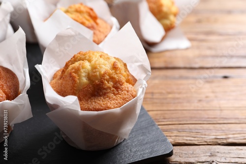 Delicious sweet muffins on wooden table, closeup. Space for text