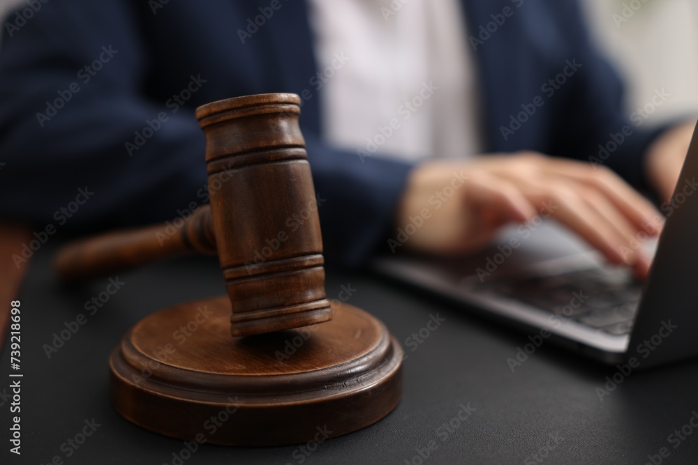 Notary working with laptop at table, focus on gavel Notary working with laptop at table, focus on gavel