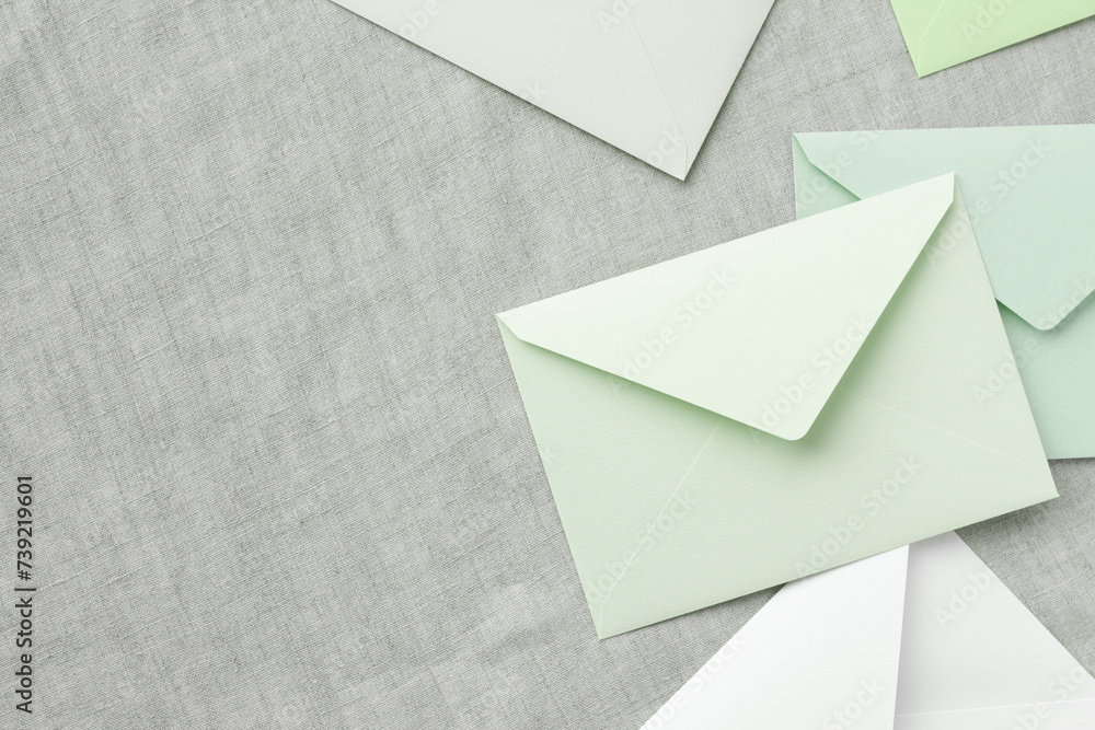 green and white envelopes are randomly placed on a gray tablecloth, leaving a copy space on the left	