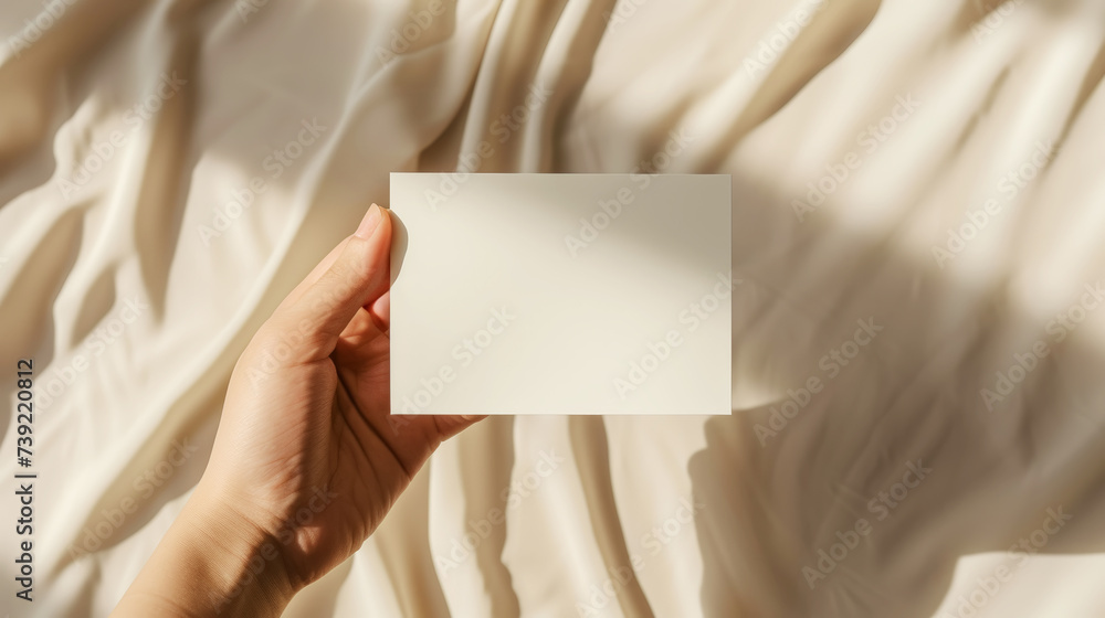 Aesthetic mockup. Woman hand holds a white blank on light backdrop with sun rays and strong shadows. Generative AI Aesthetic mockup. Woman hand holds a white blank on light backdrop with sun rays and strong shadows. Generative AI