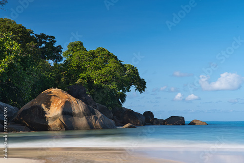 4 seconds long exposure of beautiful white sandy beach, granite rock boulders and turqouise water, Mahe, Seychelles