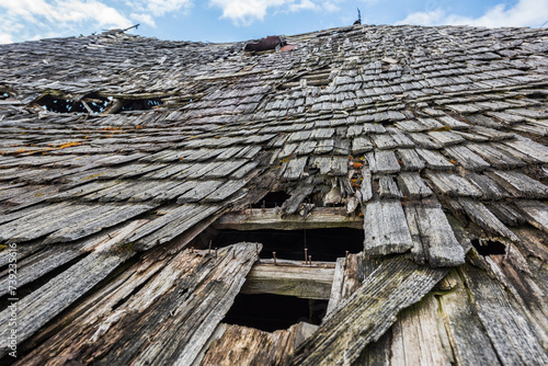 Close up, an old abandoned traditional wooden building in Romania mountain village, falling apart from the effects of atmospheric precipitation. Shallow depth of field.