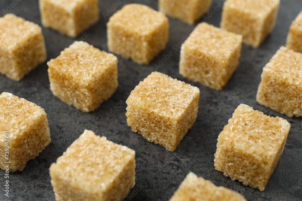 Brown sugar cubes on grey table, closeup Brown sugar cubes on grey table, closeup