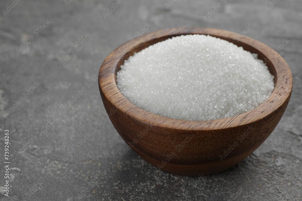 Granulated sugar in bowl on grey textured table, closeup Granulated sugar in bowl on grey textured table, closeup