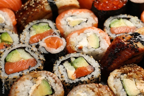 Different tasty sushi rolls as background, closeup