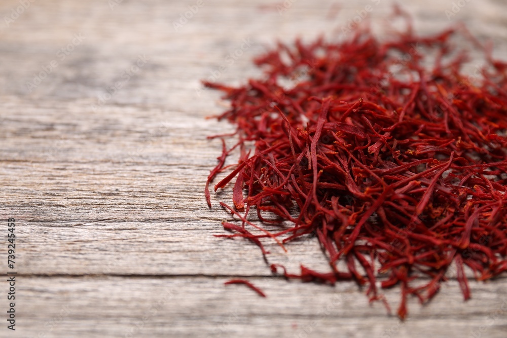 Naklejka premium Aromatic saffron on wooden table, closeup. Space for text