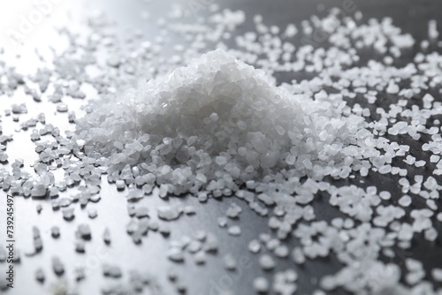 Heap of natural salt on black table, closeup