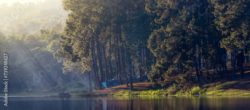 Group of tent for overnight camping with sunrise over the misty mountain and ray of light and campsite of Pang Oung, Mae Hong Son, Thailand photo