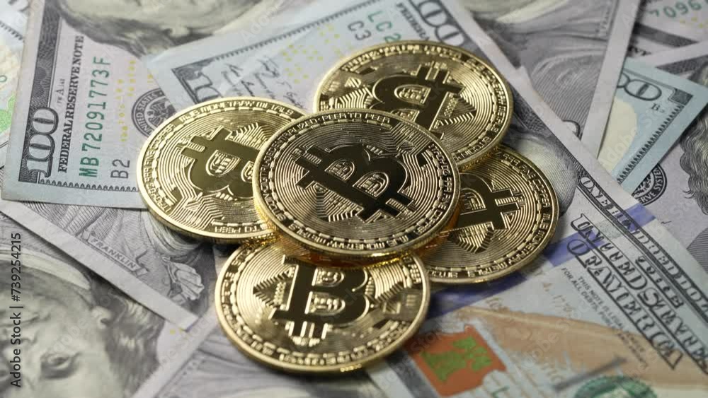 Close up of metal golden bitcoin crypto currency coins on US 100 dollar bills, rotates. Electronic decentralized money concept. Exchange bitcoin cash for a dollar. Bitcoin coin and cash background Close up of metal golden bitcoin crypto currency coins on US 100 dollar bills, rotates. Electronic decentralized money concept. Exchange bitcoin cash for a dollar. Bitcoin coin and cash background