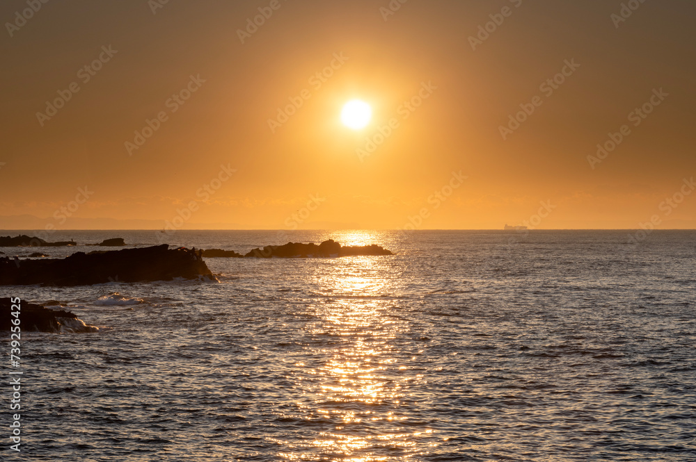 朝日のオレンジ色に染まる城ヶ島の海
