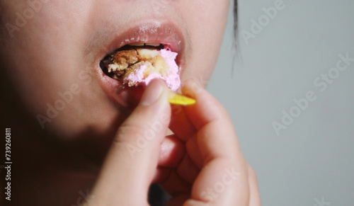 Woman eating cup cake deliciously, © jimbophotoart