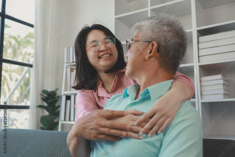 Obraz premium A father and daughter sat in the living room happily spending time together after not seeing each other for a while, A warm family is in the house, Elderly father and teenage daughter