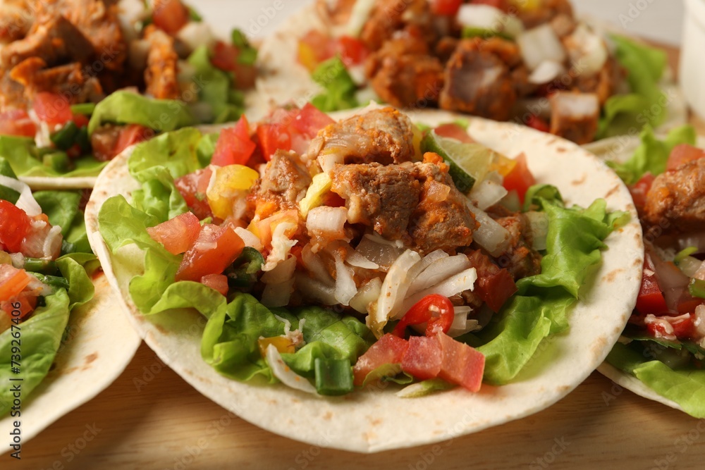 Delicious tacos with vegetables and meat on table, closeup Delicious tacos with vegetables and meat on table, closeup