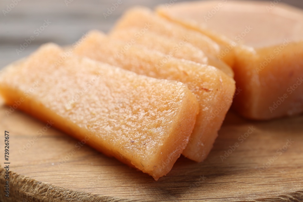 Tasty sweet quince paste on wooden board, closeup