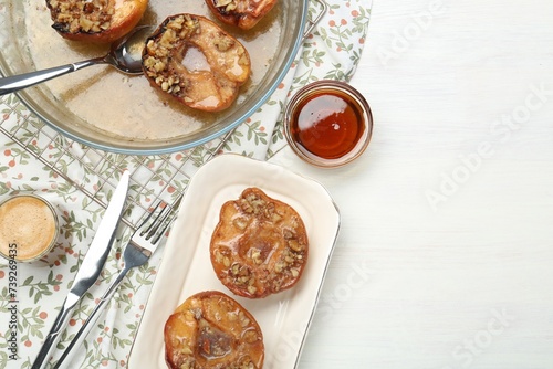 Delicious quinces baked with honey and walnuts on white wooden table, flat lay