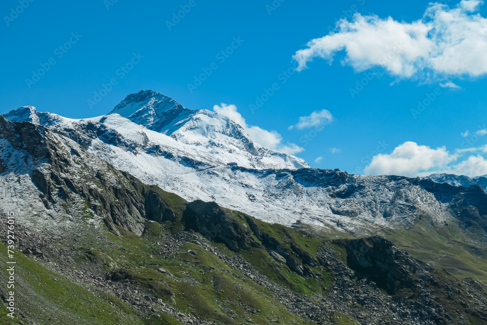 Alpine terrain with panoramic view of Hannoverhaus below majestic snow covered mountain peak Ankogel seen in High Tauern National Park, Carinthia, Austria. Idyllic hiking trail in summer Austrian Alps