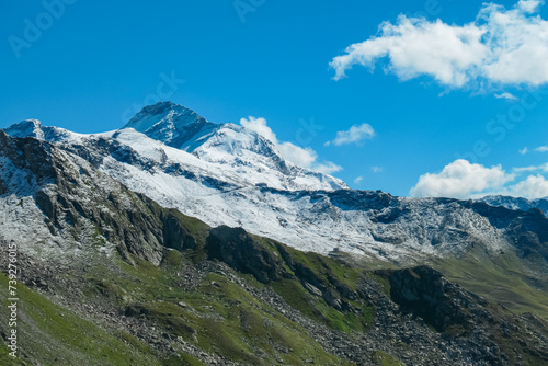 Alpine terrain with panoramic view of Hannoverhaus below majestic snow covered mountain peak Ankogel seen in High Tauern National Park  Carinthia  Austria. Idyllic hiking trail in summer Austrian Alps