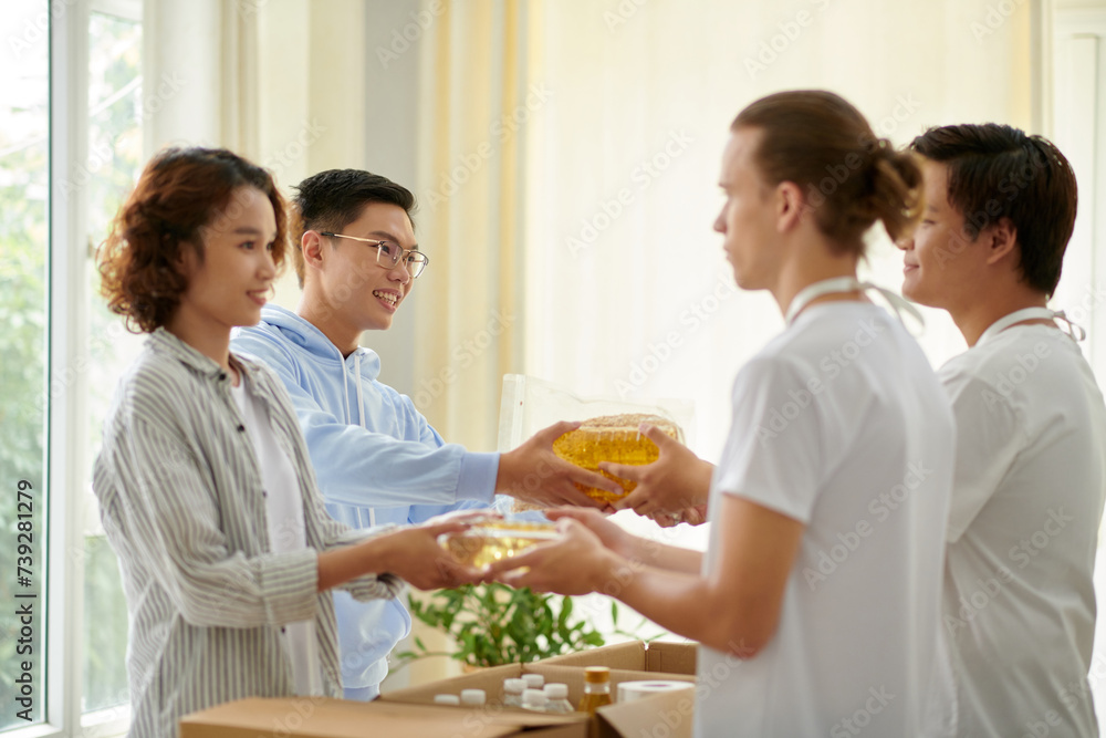 People bringing food to donate to charity organization People bringing food to donate to charity organization