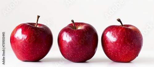 Three vibrant red apples on a clean white background for healthy eating concept
