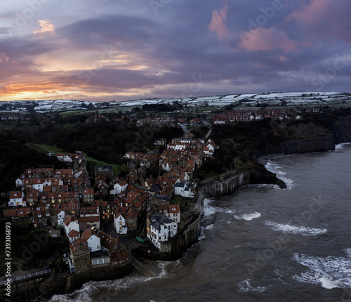 Robin Hoods Bay in snow sunset tide in