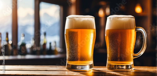 Obraz na płótnie Two mugs of light beer with foam standing on a wooden table in a bar or room with windows and sunlight in the background, with space for text, advertising and banner for beer w salonie