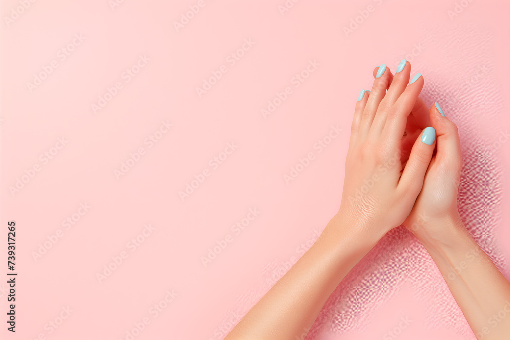 Female hands with blue manicure on a pink background. Flat lay, top view.