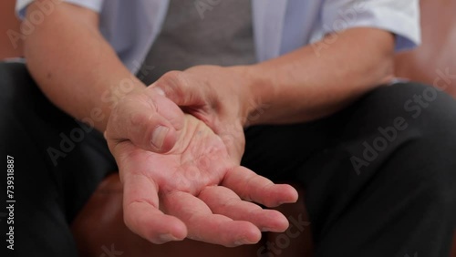 An elderly man massages his hands because of pain and aches. Bone and degenerative joint disease. Elderly health care concept photo
