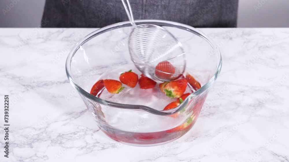 Preparing Strawberries in a Glass Mixing Bowl with Water Preparing Strawberries in a Glass Mixing Bowl with Water