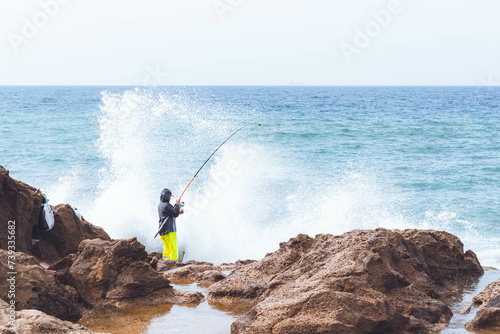 A man fishing in the Atlantic ocean on the coast of Tangier in Morocco 