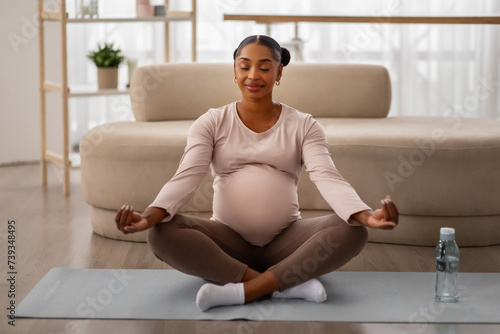 Peaceful african american woman meditating at home