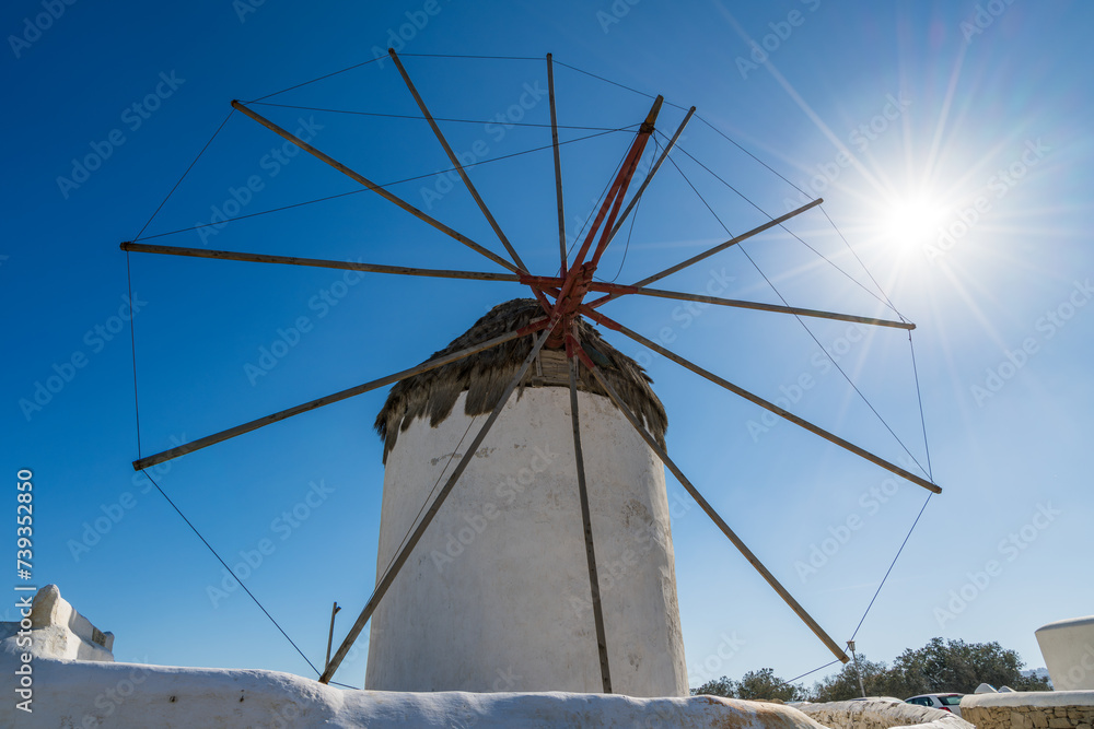 Famous Windmill of Mykonos with sun flare.  Mykonos Island.  Greece
