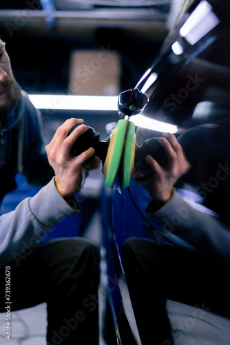 close-up of the hands of a car mechanic at a service station doing the final polishing to shine