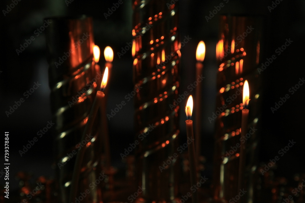 Fire of memory. Turning to God. Silent prayer. A burning candles in the dark against the background of the iconostasis in the old church. A symbol of sacrifice and memory, health and peace