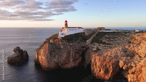 Flight towards the Cabo de Sao Vicente fort and lighthouse at sunset, Portugal 