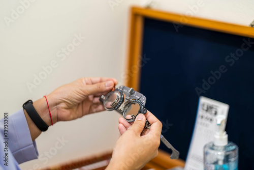 Hand changes lenses half test trial of glasses high eyes. frame phoropter set of corrective myopia optician instrument. mirror is equipment contains lens of ophthalmologist.