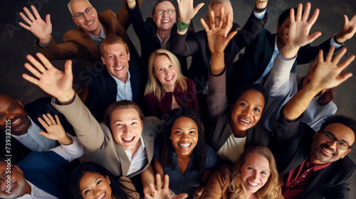 Diverse group of cheerful colleagues celebrating success with raised hands